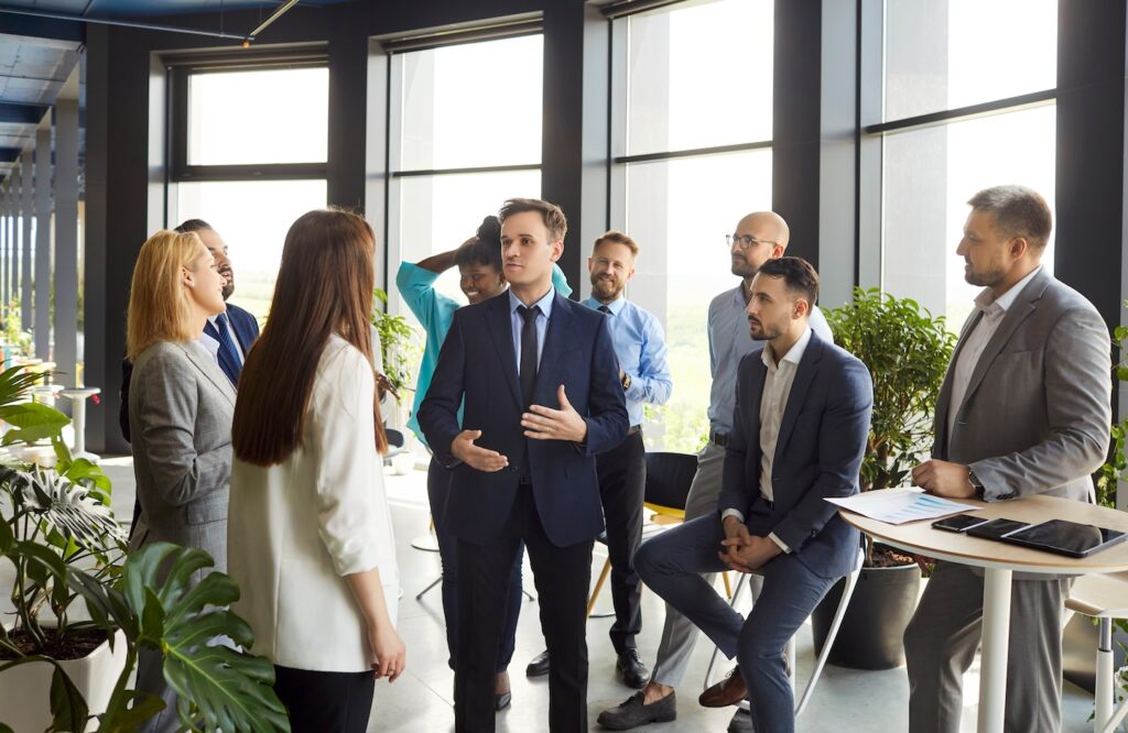 Hook Agency’s team discusses lead generation strategies in a modern office, sharing actionable insights and engaging together.