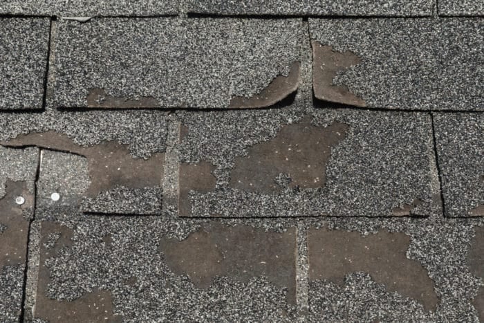Asphalt shingle granules washed away on damaged roof