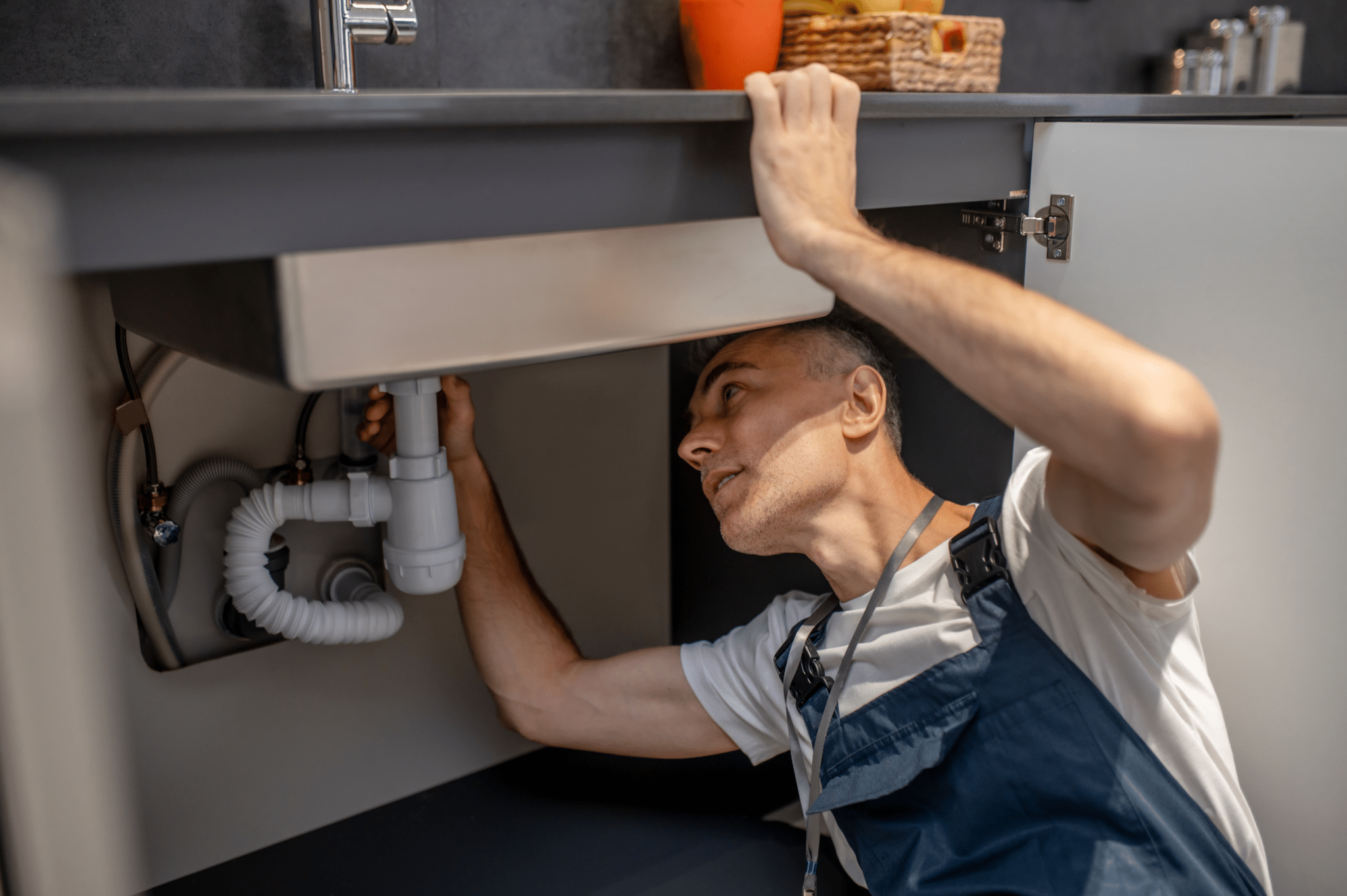 A plumber fixing the kitchen sink.