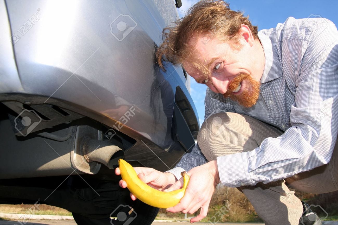 Man shoving banana up exhaust pipe - worst stock images ever