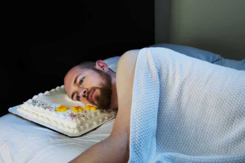 Man with cake as pillow stock images