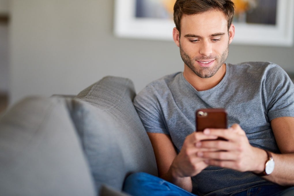 Young man texting on his cellphone receives an offer from business facing a labor shortage
