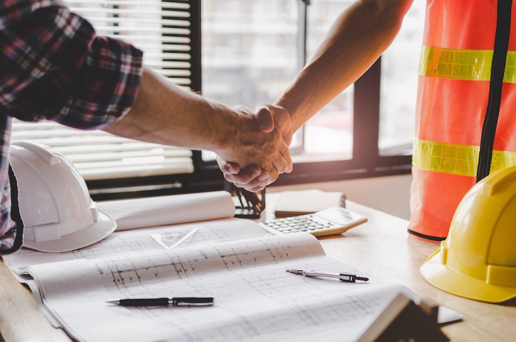 construction worker team hands shaking after hiring after labor shortage