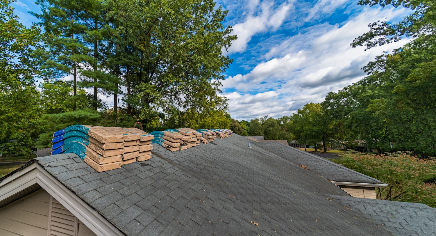 shingle bundles on asphalt roof in need of repair