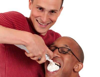 Man feeding another man whipped cream stock photo - strange stock photos for memes