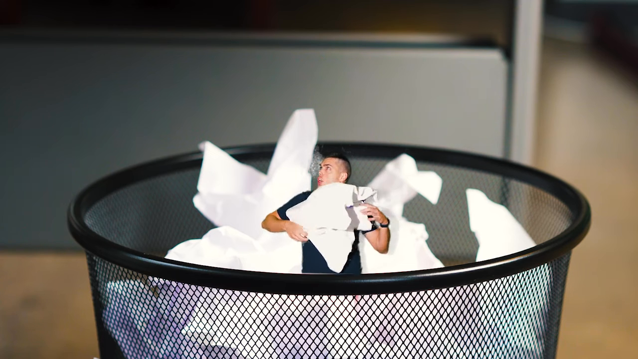 a small man standing inside a mesh trash bin