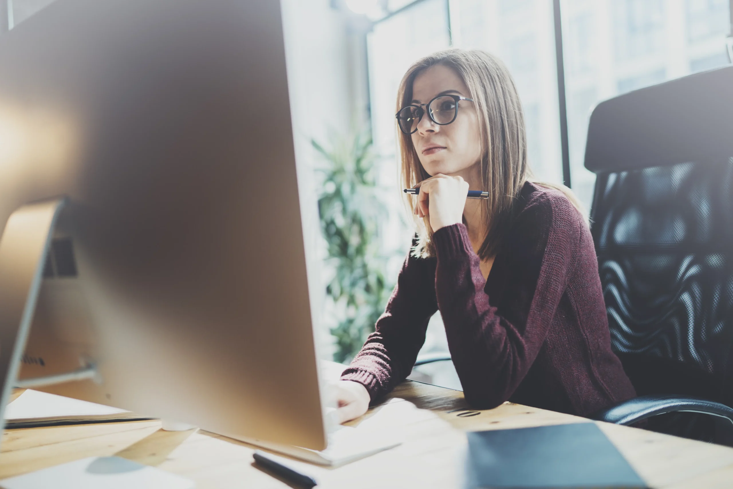 Woman working on her computer, reviewing SEO strategies, representing the data-driven approach of an Indianapolis SEO agency to improve search engine rankings and drive local business growth through targeted SEO efforts.