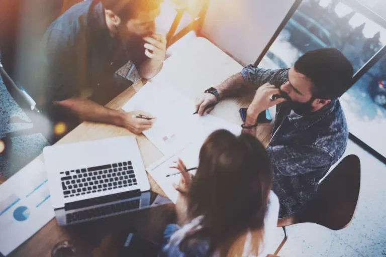 Overhead view of a team of marketers collaborating in an office, representing the strategic approach of an Eau Claire web design agency, focused on delivering innovative website solutions and digital marketing strategies to boost local business growth.