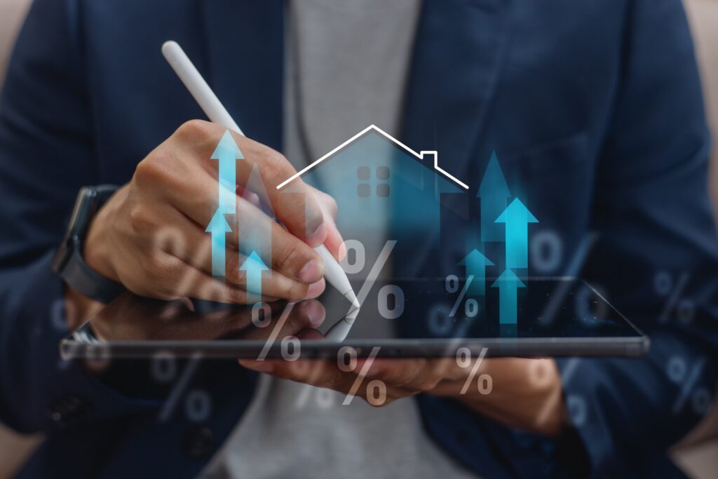 A professional in a dark suit utilizes a tablet with a stylus, overlaid with graphics depicting a house, percentage symbols, and upward-pointing arrows. These visuals symbolize financial growth and increasing real estate interest rates, paralleling the surge in positive Google reviews for reputable HVAC accountants.