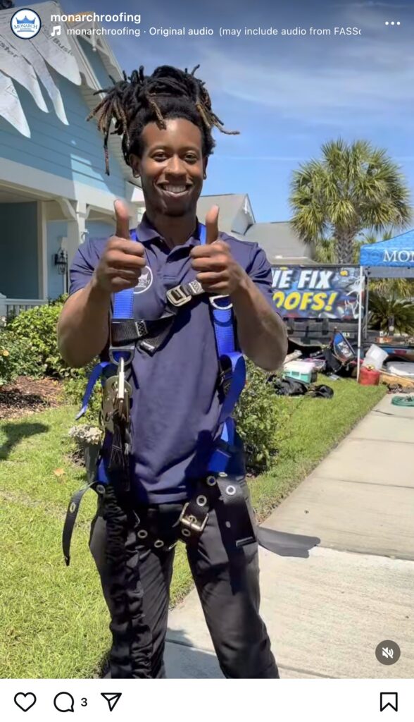 A team member in a safety harness and branded shirt gives a confident thumbs up outside a home, standing beside our “WE FIX ROOFS!” banner. Professional roofing equipment and palm trees set the scene under clear blue skies as we celebrate National Roofing Week.