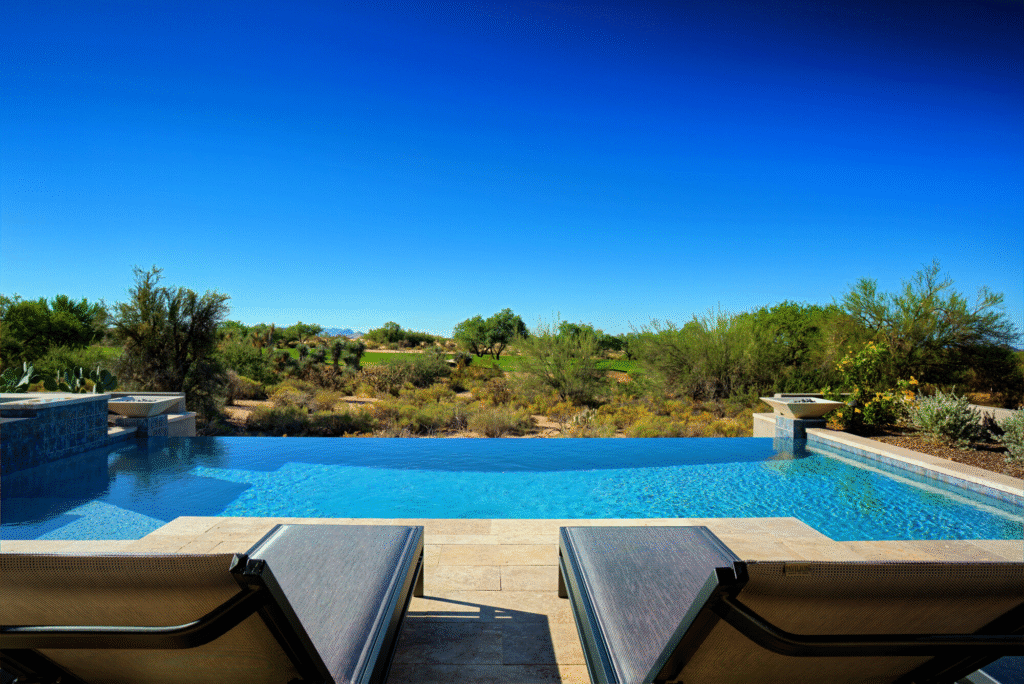 Infinity pool with clear blue water, lounge chairs, and desert views—expertly installed by top U.S. pool professionals.