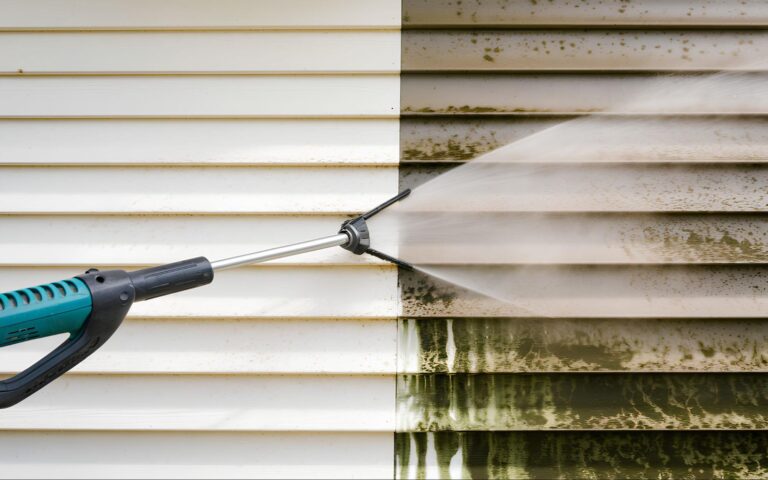 Power washer cleans white siding, clearly showing the dramatic before-and-after results of effective siding SEO services.