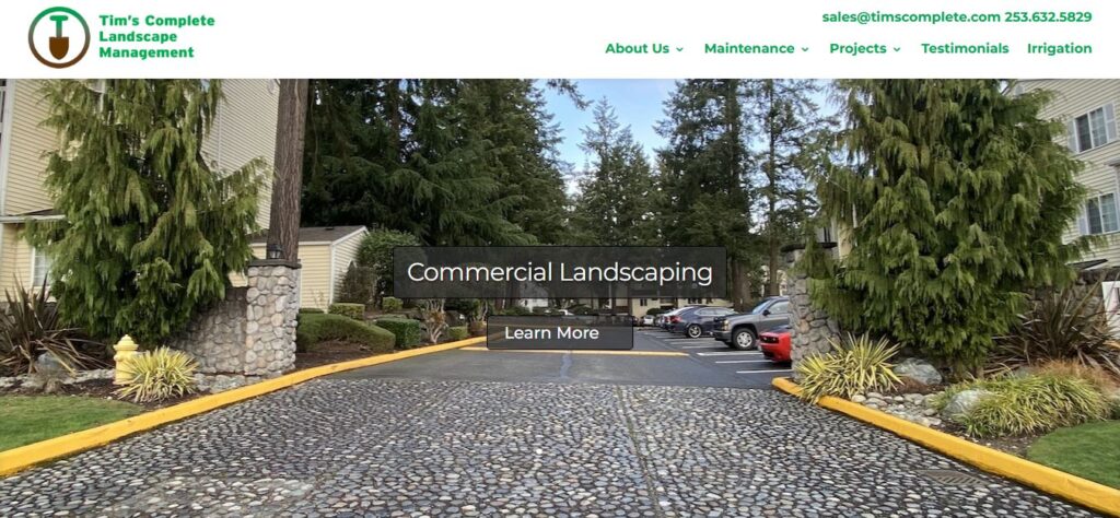 Paved driveway with stone edging, manicured landscaping, tall evergreens—exemplifying top-tier hardscaping. "Commercial Landscaping" overlay, "Learn More" button. Hook Agency logo and contact info at top.