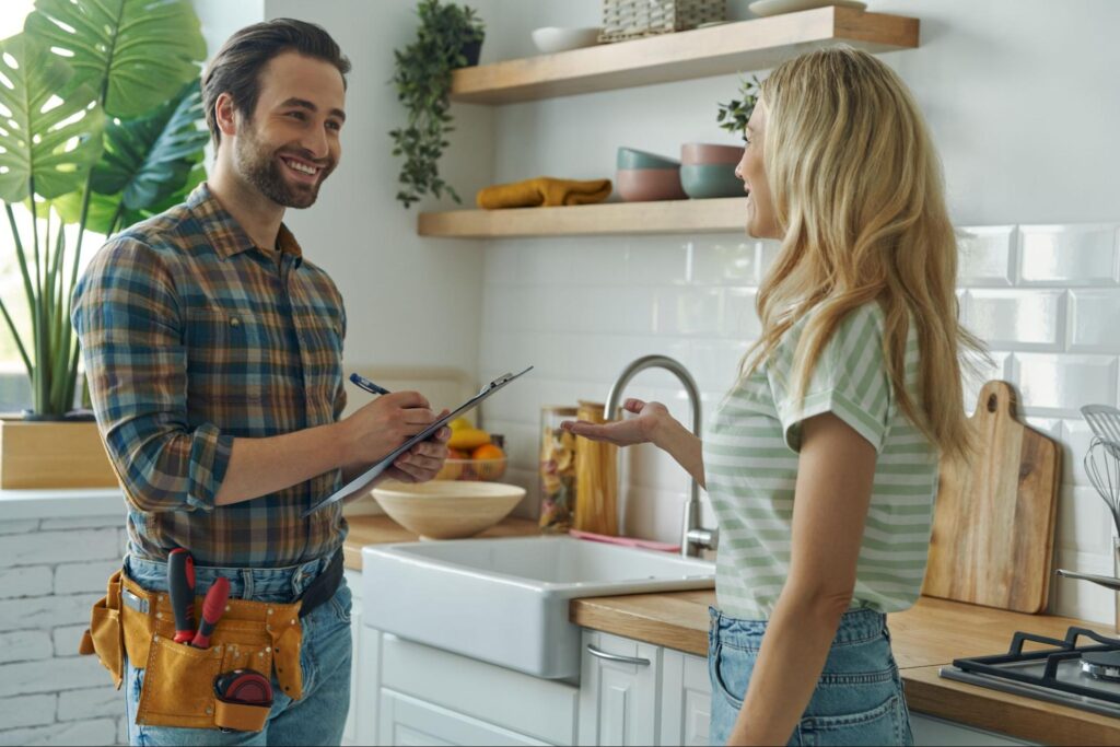A handyman consults with a client in a modern kitchen, illustrating how strong contractor marketing builds trust and drives engagement.