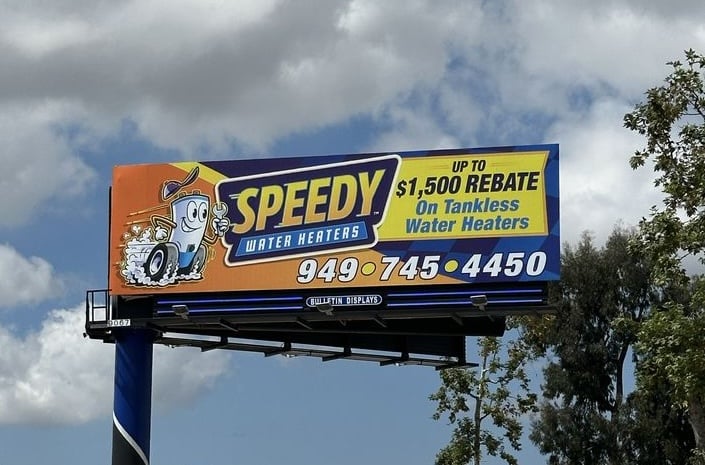 Billboard for Speedy Water Heaters promotes up to $1,500 rebate on tankless water heaters and showcases expertise in installation and repair. Features a recognizable cartoon mascot, contact number 949-745-4450, against a cloudy sky—an actionable call to upgrade your system through Hook Agency’s trusted partner.