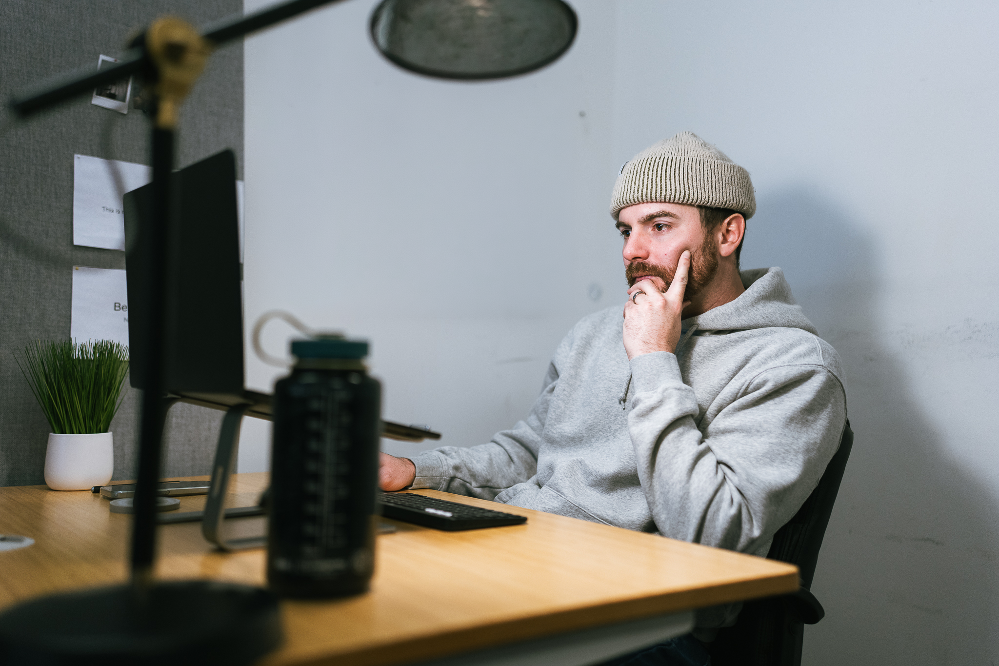 A marketing professional reviews Meta ads on a monitor at his desk, focused and engaged—Hook Agency workspace in view.