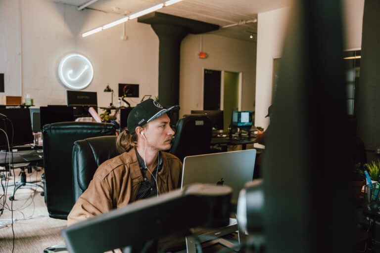 A team member works on a laptop at a Hook Agency digital marketing office.